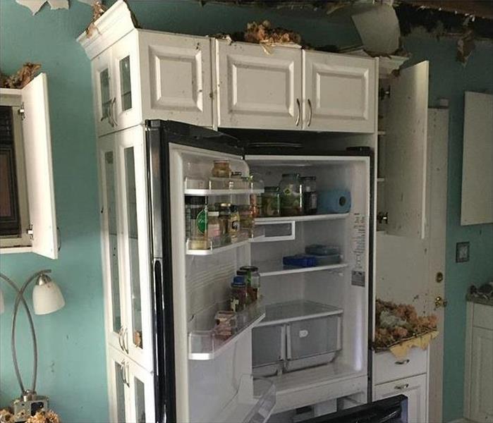 kitchen fire, ceiling damage, fridge, and white cabinets