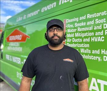 male, black shirt and beard in front of truck.