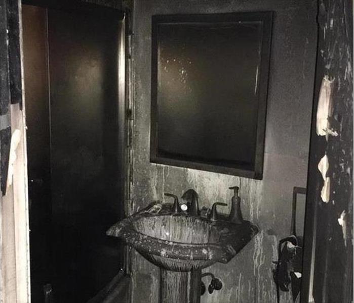 blackened soot pedestal and mirror in a bathroom