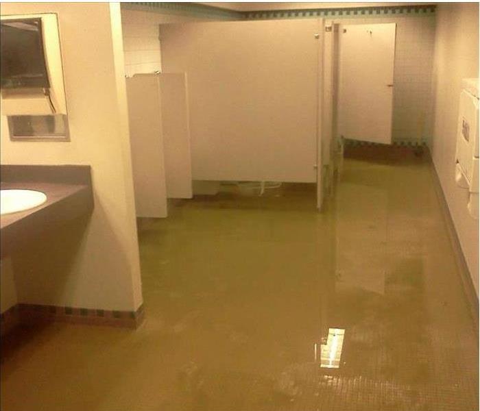 flooded restroom floor on brown tiles