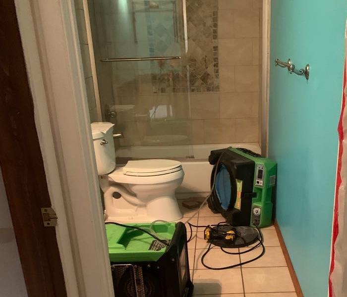 Water damage dry out being preformed in residential bathroom
